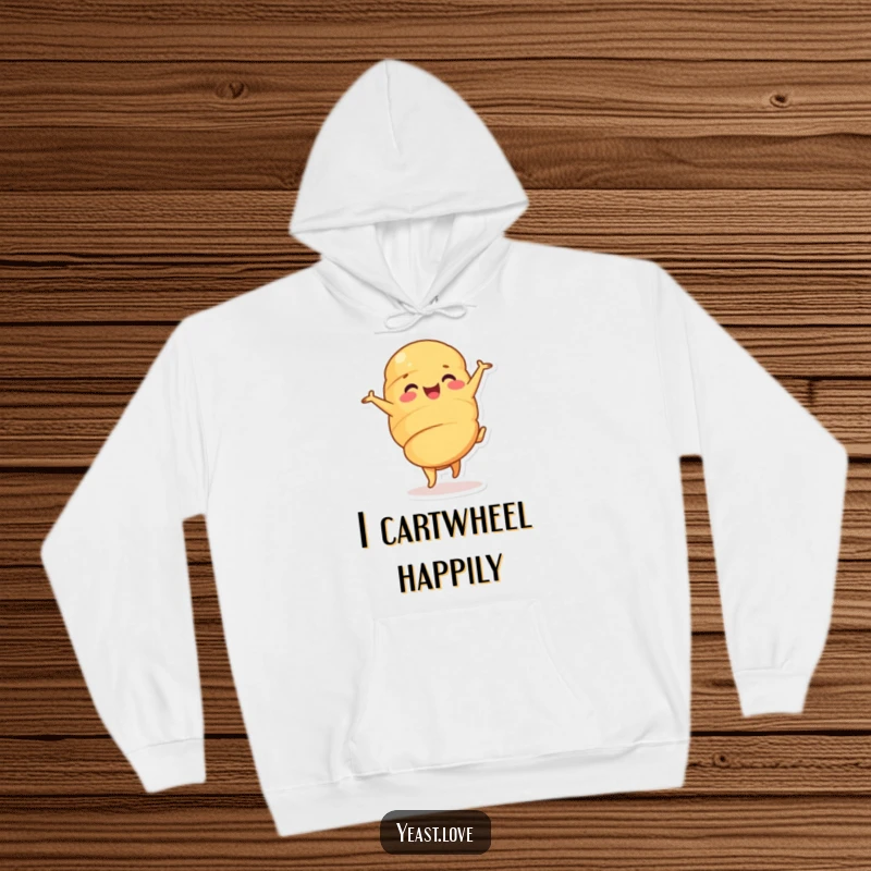 Funny croissant hoodie featuring a happy dessert character in an energetic cartwheel. Cozy and humorous outerwear.